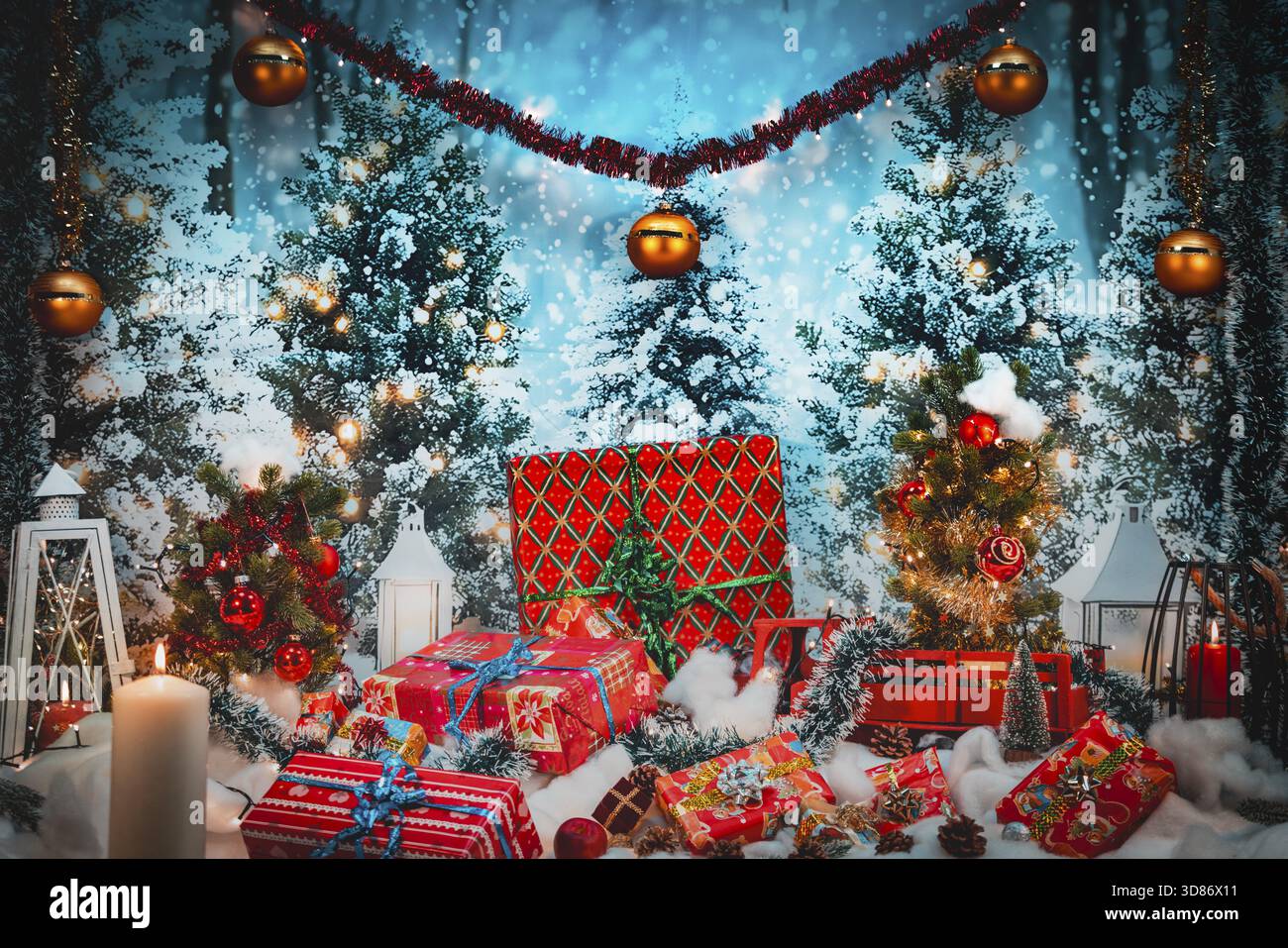 Décor festif avec des cadeaux devant des arbres de Noël enneigés et des lumières Banque D'Images