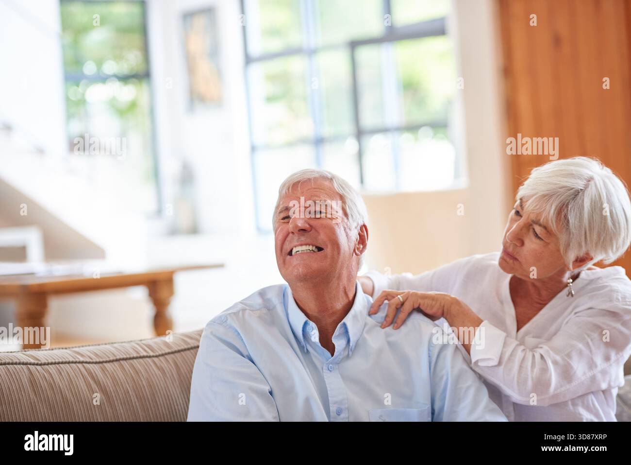 Masser l'épaule, la femme et le mari sur le canapé, la douleur et la liaison avec le support. Appartement, relation et homme sur le canapé, femme et amour avec Banque D'Images