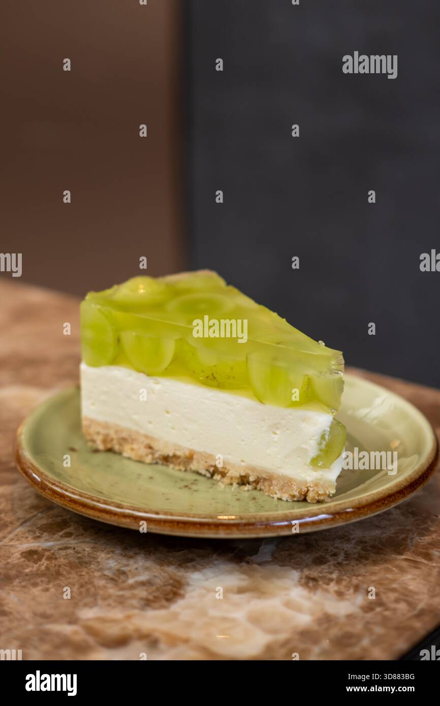 Briller la gelée de raisin muscat, sur le cheesecake avec une base de crumble servie dans l'assiette Banque D'Images