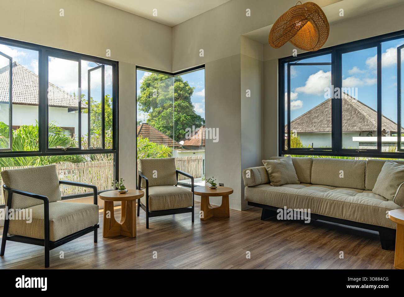 Un salon avec un canapé, deux chaises et une table. La chambre a une atmosphère chaleureuse et accueillante Banque D'Images