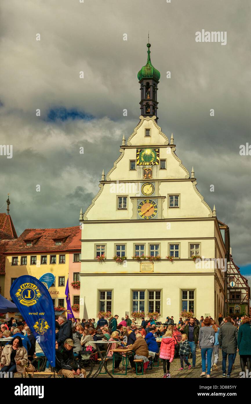 Gros plan de l'historique Ratsherrntrinkstube avec son pignon à gradins Renaissance et sa tour de l'horloge proéminente, entouré d'une foule animée à Rothenburg Banque D'Images