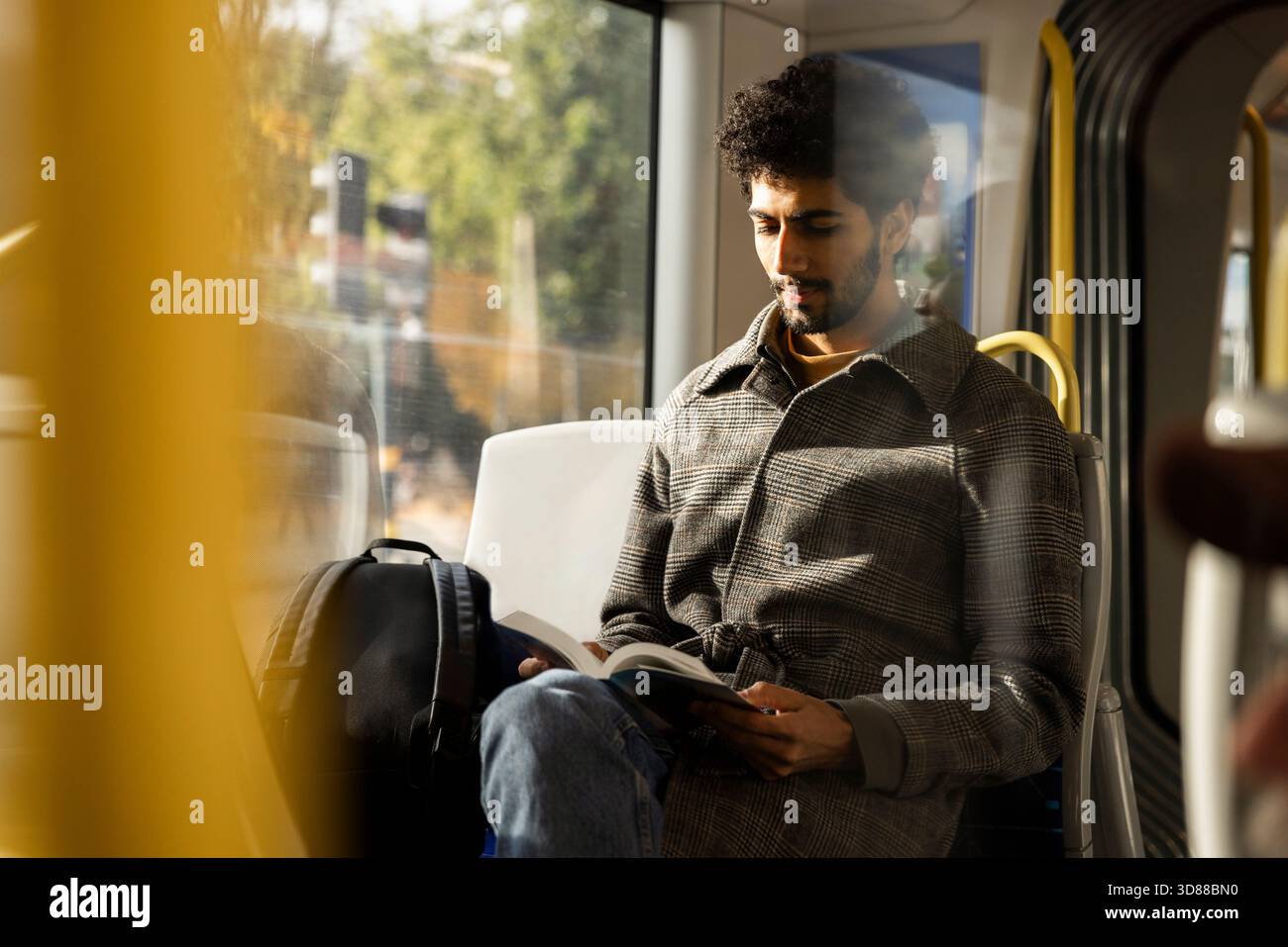 Homme lisant le livre tout en voyageant dans le bus Banque D'Images