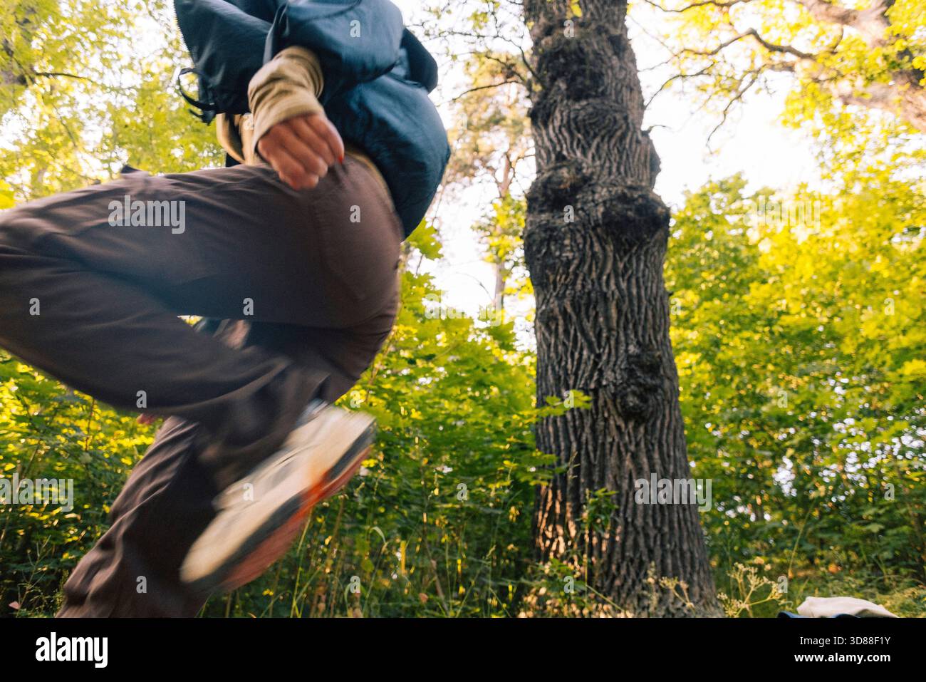 Vue à angle bas de femme courant dans la forêt Banque D'Images