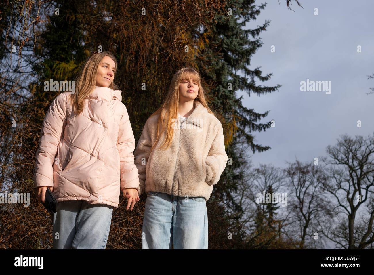 Une mère et sa fille adolescente flânent ensemble dans un environnement extérieur paisible, soulignant leur relation étroite et partagé des moments de joie A. Banque D'Images