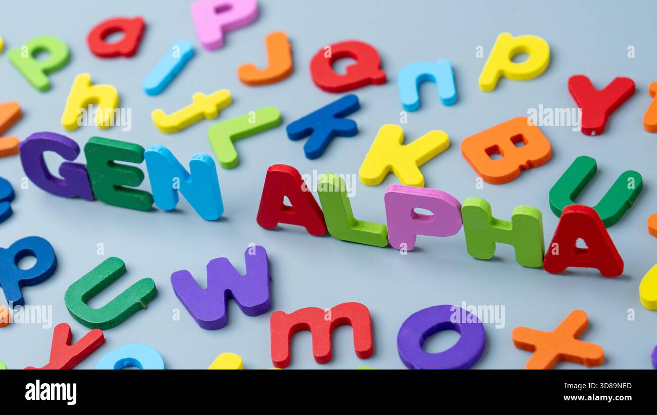Lettres colorées de l’alphabet en bois disposées pour former l’expression « GEN ALPHA », symbolisant la génération Alpha. Enfance moderne, natifs numériques, apprentissage précoce Banque D'Images