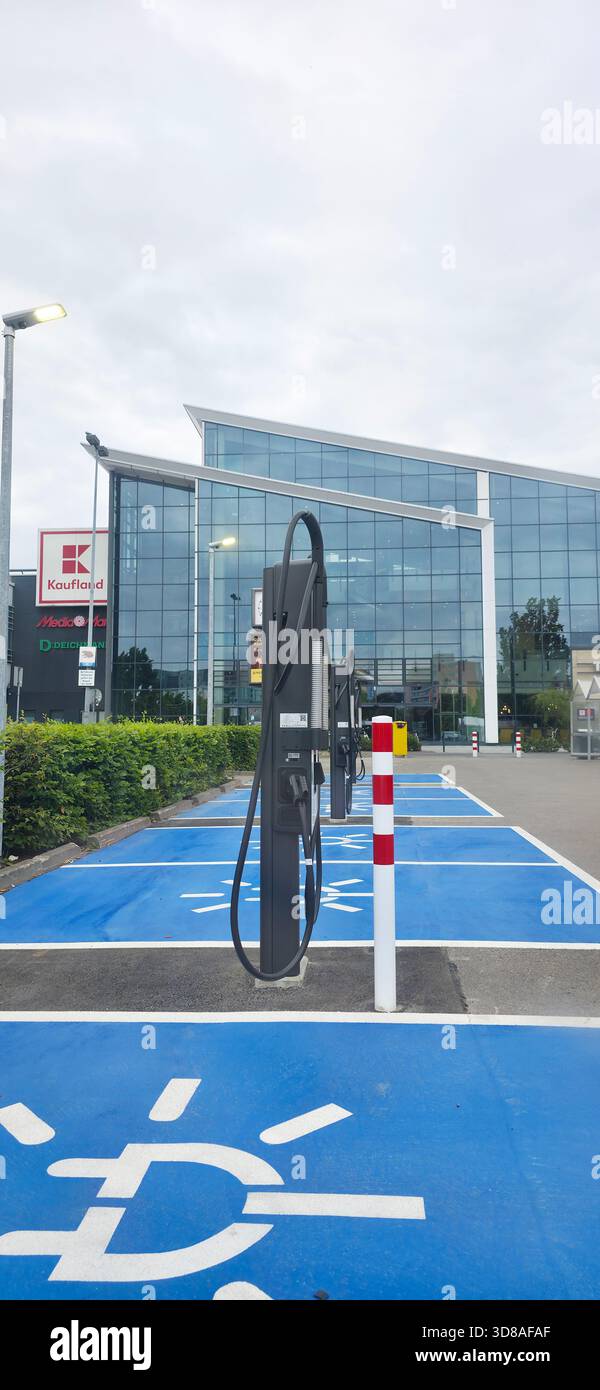 Berlin, Allemagne - 28 juin 2025 : borne de recharge pour véhicules électriques située à l'extérieur d'un bâtiment contemporain en verre. - Image de stock capturée avec un smartphone