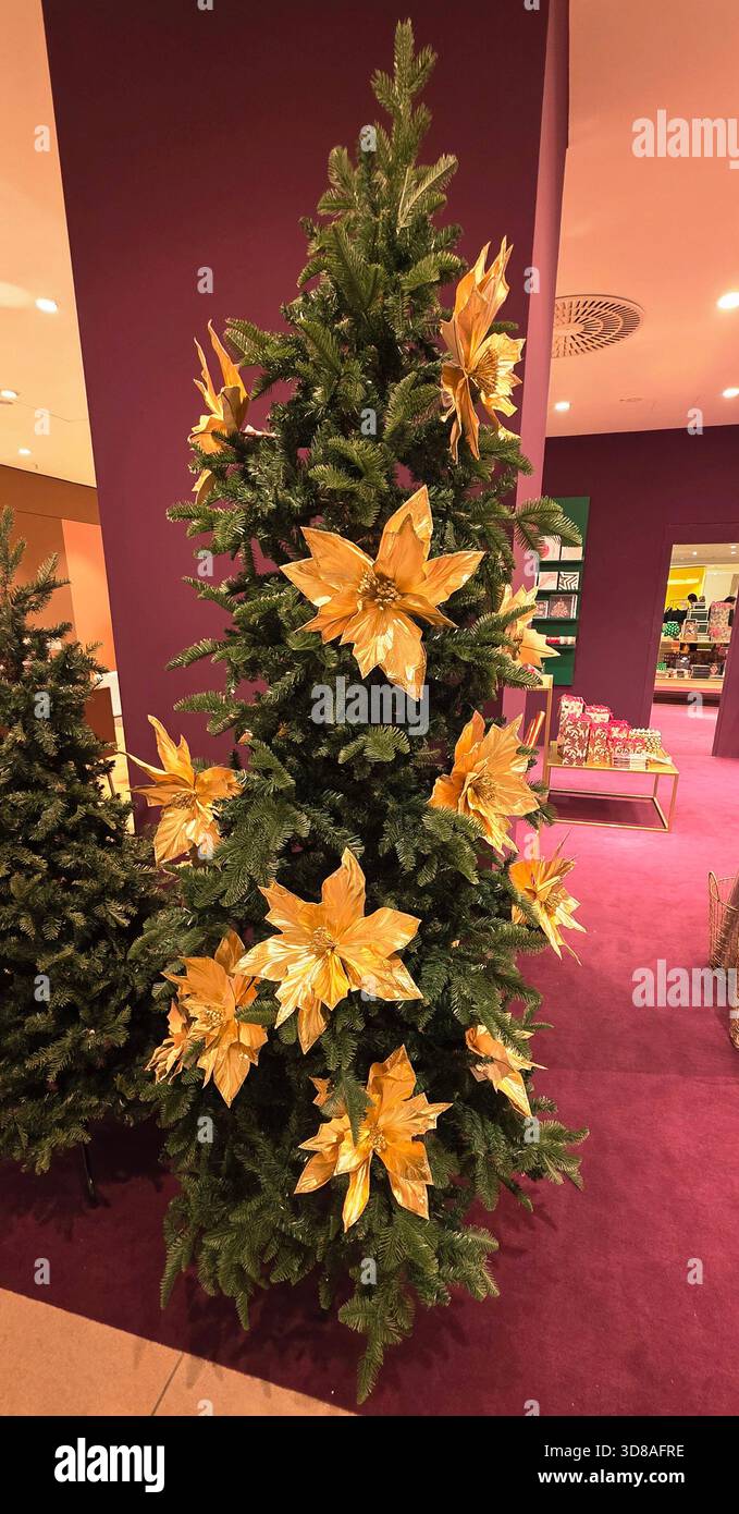Berlin, Allemagne - 19 septembre 2025 : magnifique arbre de Noël décoré de fleurs dorées dans une atmosphère de vacances vibrante. - Image de stock capturée avec un smartphone