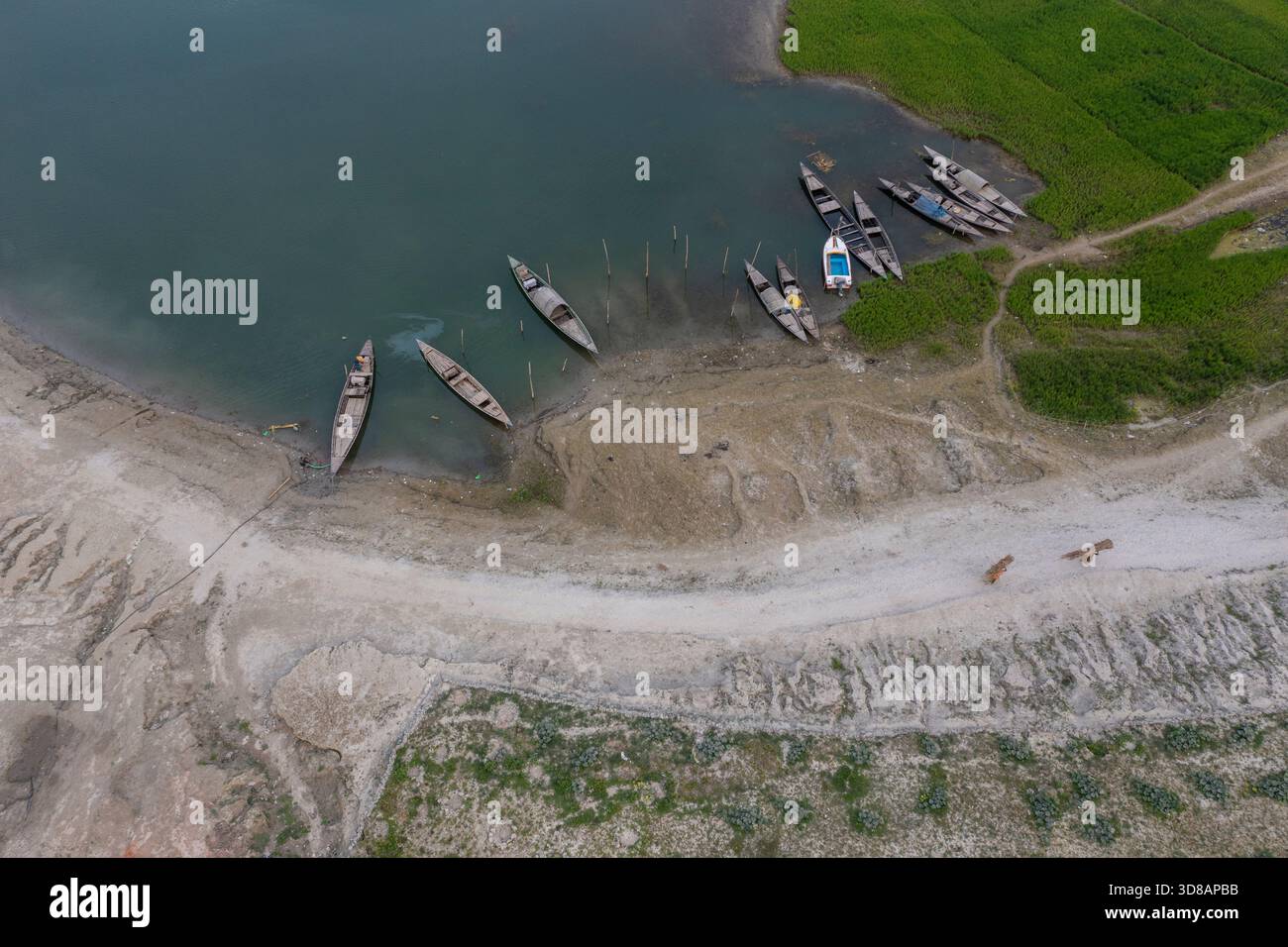 Des bateaux sont ancrés le long de la rive desséchée de la rivière Jamuna pendant l'hiver à Shariakandi, Bogra, Bangladesh. Banque D'Images