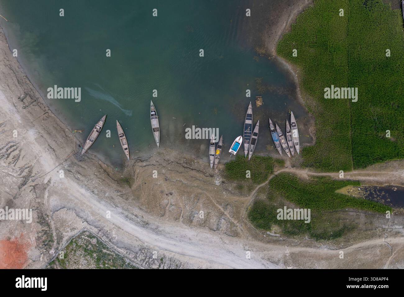 Des bateaux sont ancrés le long de la rive desséchée de la rivière Jamuna pendant l'hiver à Shariakandi, Bogra, Bangladesh. Banque D'Images