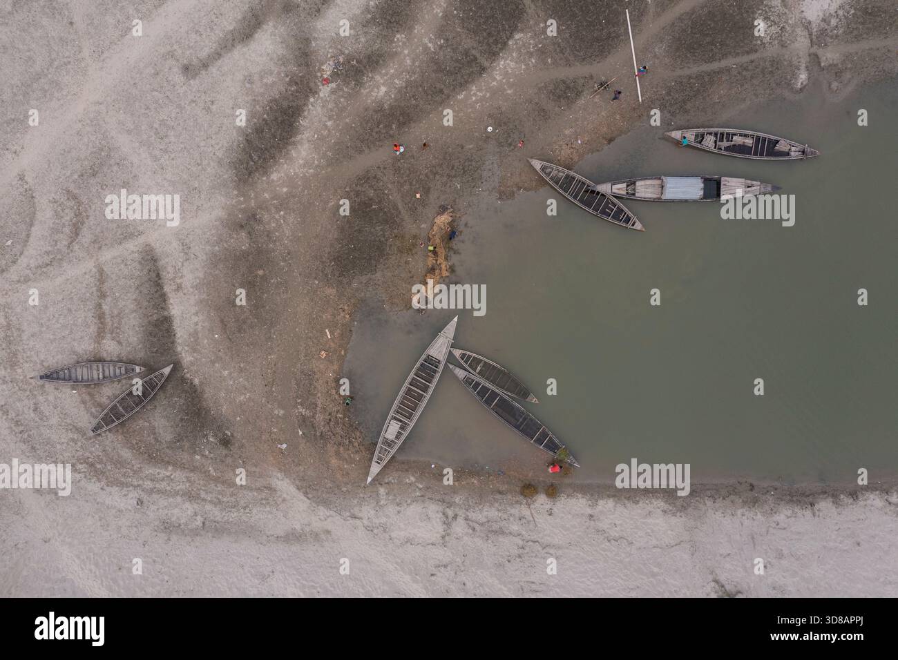 Des bateaux sont ancrés le long de la rive desséchée de la rivière Jamuna pendant l'hiver à Shariakandi, Bogra, Bangladesh. Banque D'Images