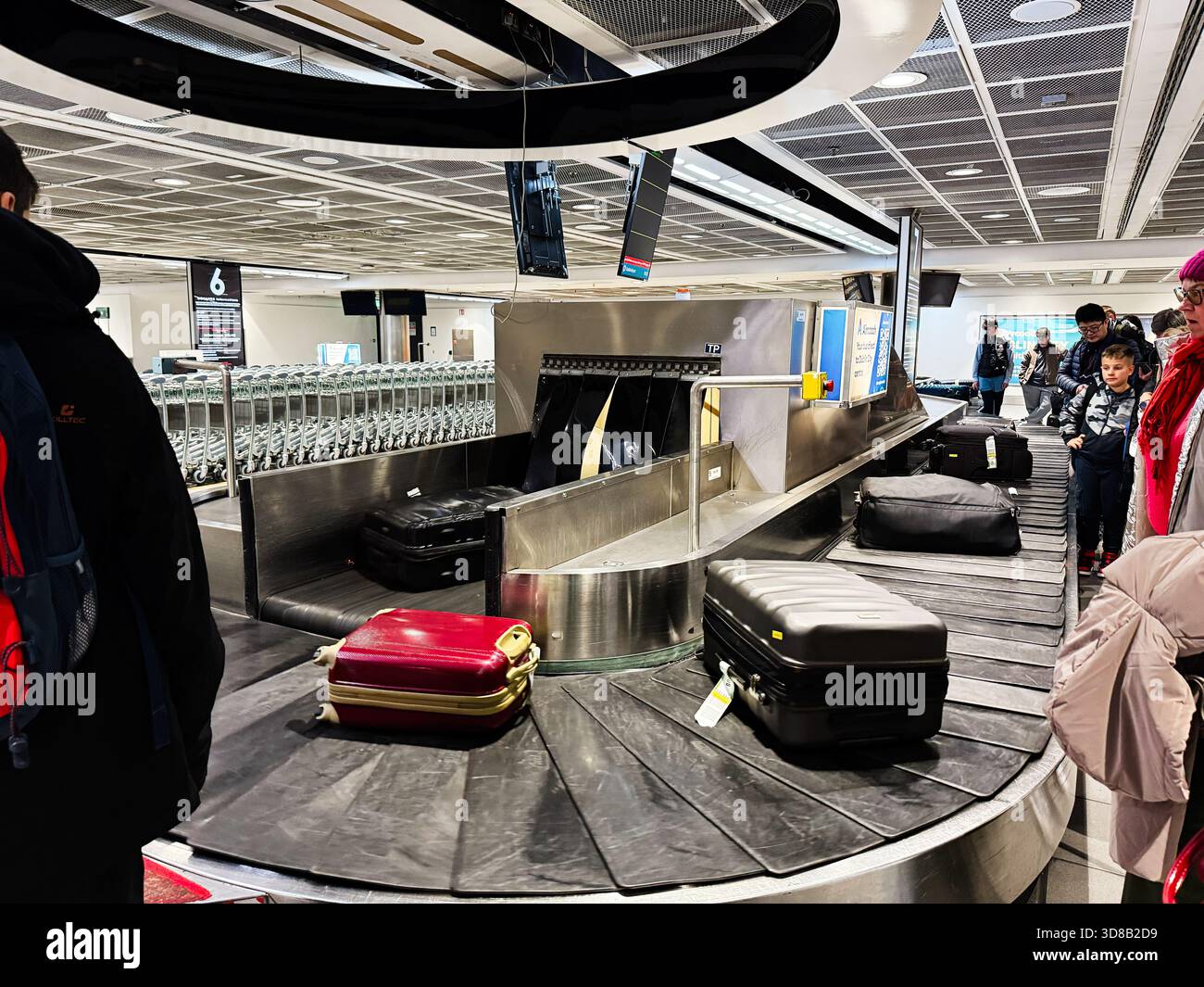 Dublin, Irlande - 21 octobre 2025 : les bagages se déplacent sur un carrousel à bagages à l'aéroport de Dublin pendant que les voyageurs attendent. Banque D'Images