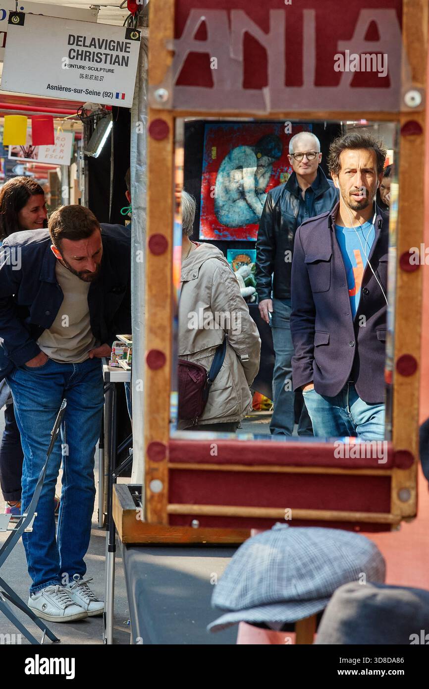 Paris, France - juin 2025 : les visiteurs parcourent le marché Edgar Quinet à Montparnasse, Paris, avec divers stands et un miroir réfléchissant. Le live Banque D'Images