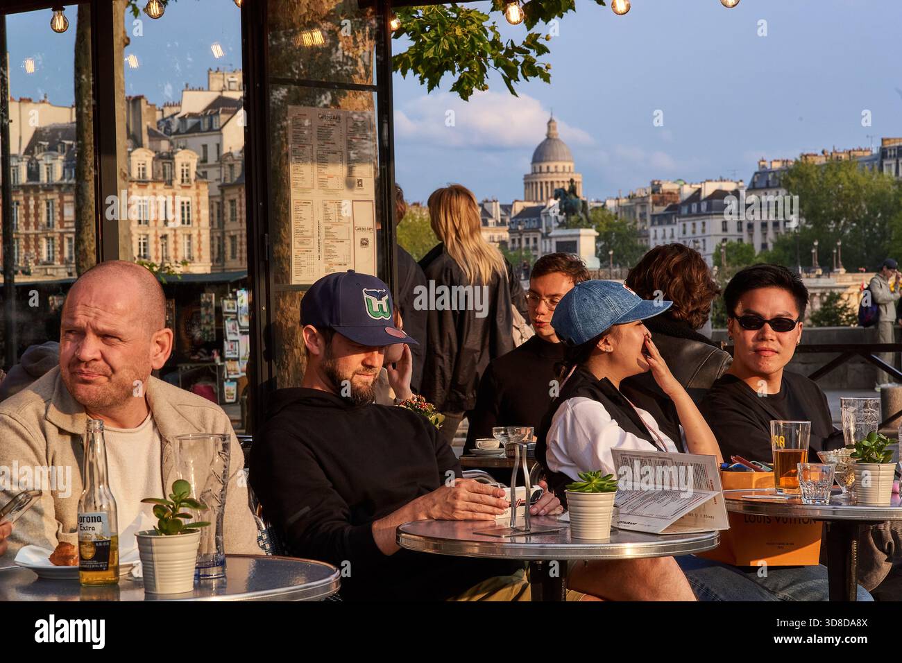 Paris, France - juin 2025 : les visiteurs apprécient les boissons et la conversation au Café des Arts sur les rives de la Seine à Paris. Le dôme du Panthéon Banque D'Images