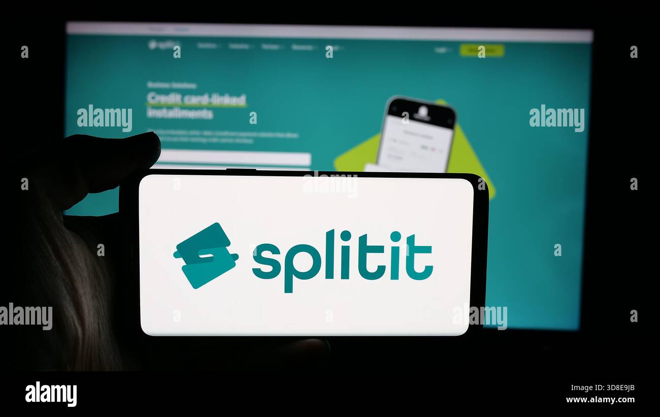 Stuttgart, Allemagne - 11-21-2025 : personne tenant le téléphone portable avec le logo de acheter maintenant payer plus tard la société Splitit USA Inc. sur l'écran en face de la page Web. Banque D'Images