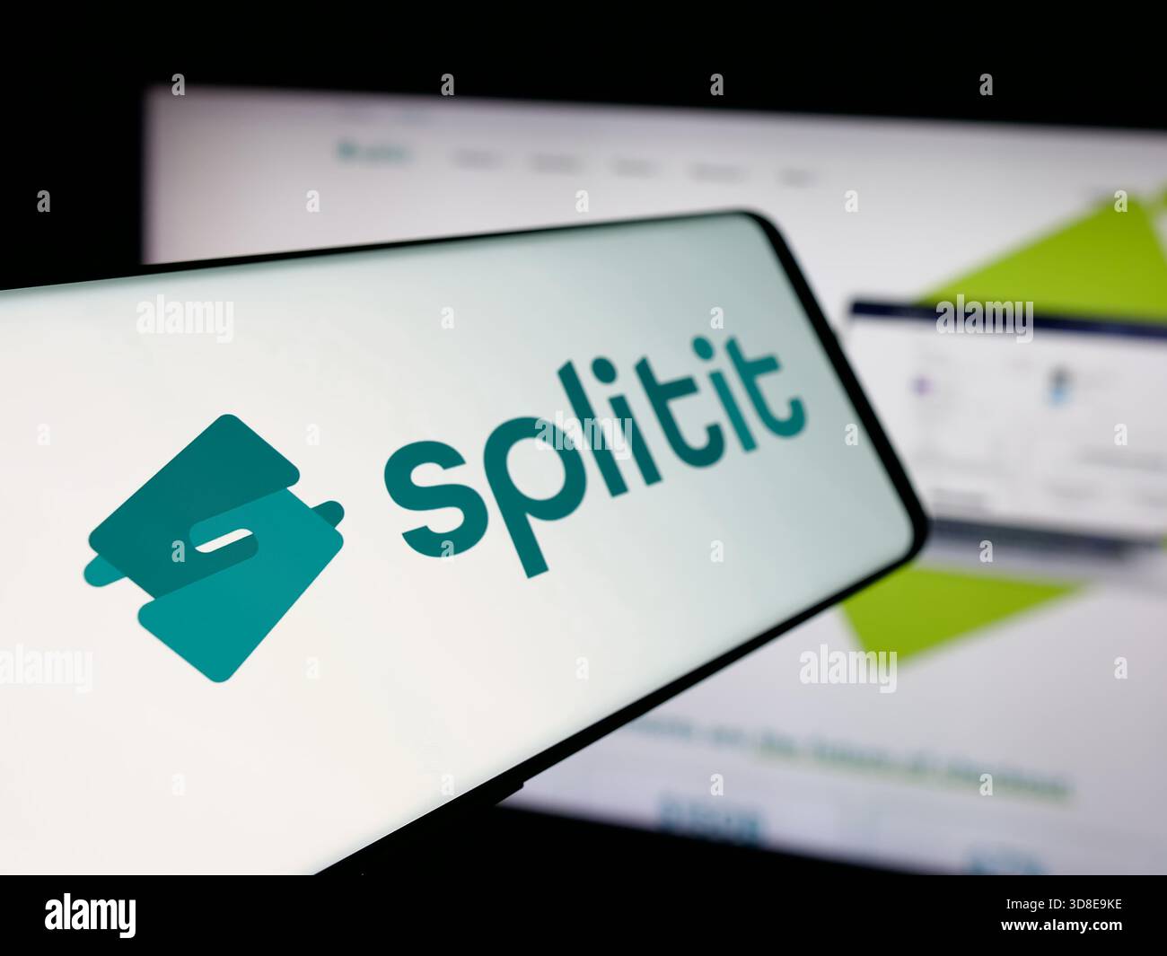 Stuttgart, Allemagne - 11-21-2025 : smartphone avec le logo de la société acheter maintenant payer plus tard Splitit USA Inc. sur l'écran en face du site. Banque D'Images
