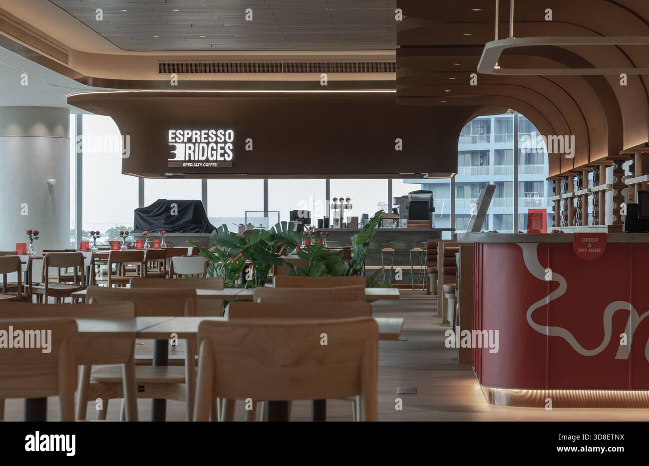 Bangkok, Thaïlande - 18 octobre 2025 - le design contemporain rencontre les vues urbaines dans ce café moderne, avec des éléments en bois gracieux et courbés et un grand vent Banque D'Images