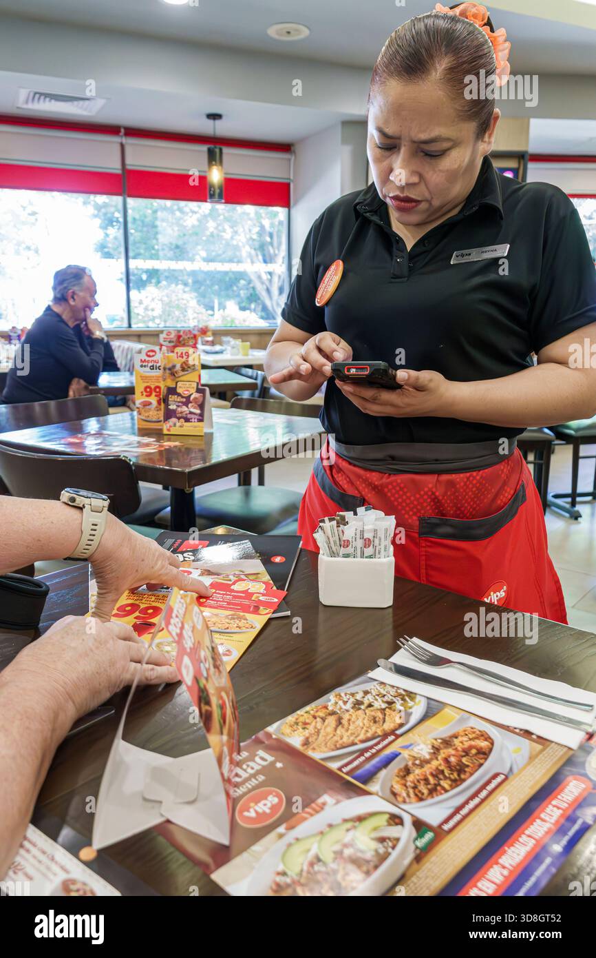 Mexico Mexique, Benito Juarez, VIP Universidad restaurant, serveuse à l'aide d'un appareil portable, prise de commande, moment de service rapproché, serveur de femme adulte, Cu Banque D'Images