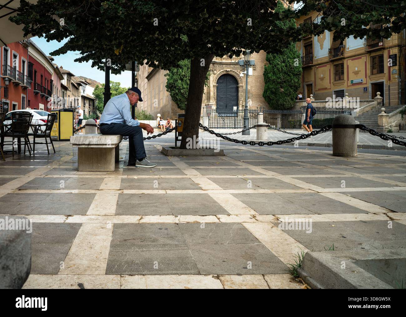 Grenade, Espagne, 2024-09-17, un vieil homme assis sur un banc de marbre sur la Plaza de Santa Ana Banque D'Images