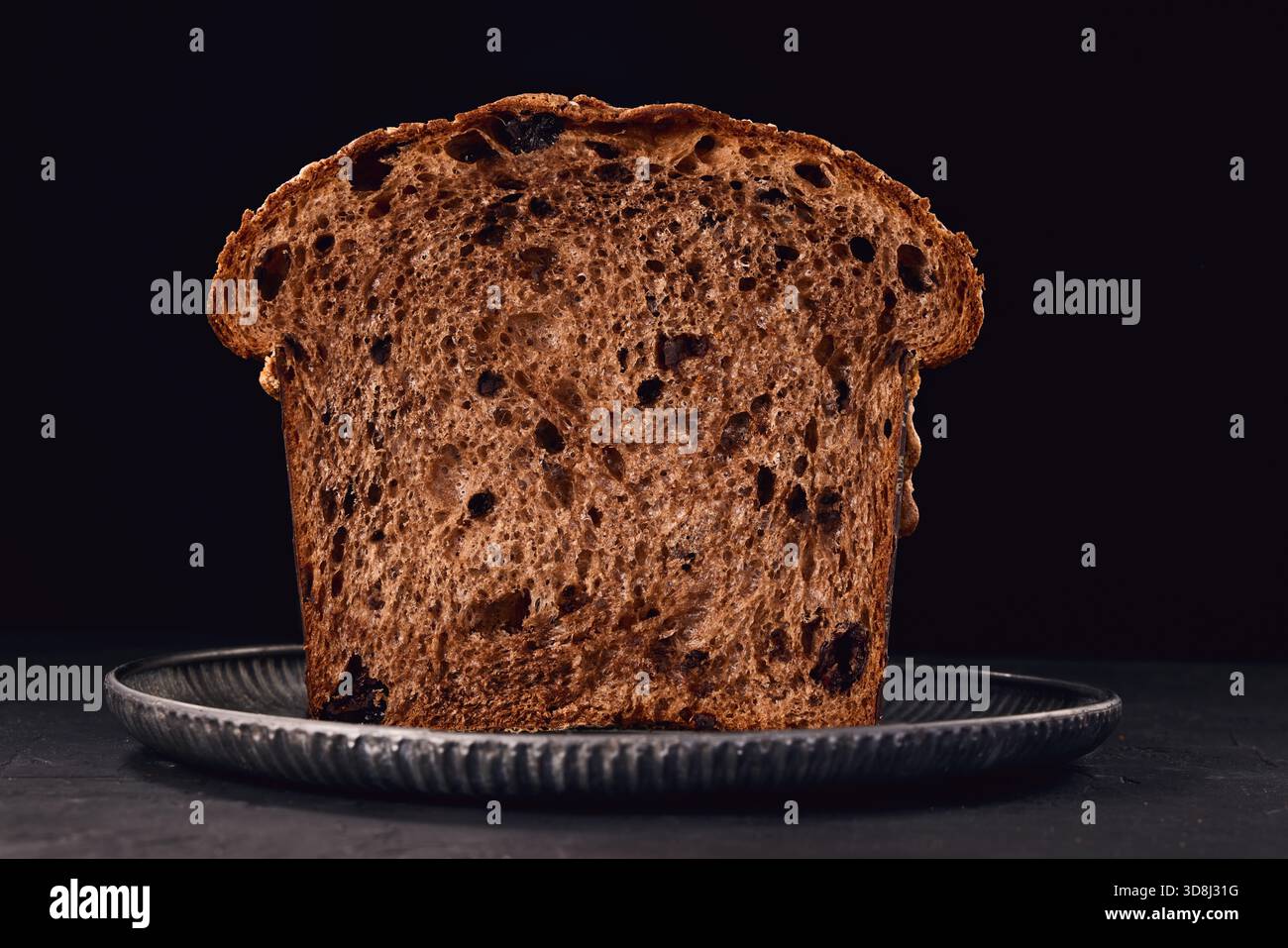 Panettone gâteau italien de Noël, pain doux traditionnel sucré avec des noix, des raisins secs et du chocolat dans une assiette rustique avec photographie alimentaire de décoration de sucre Banque D'Images