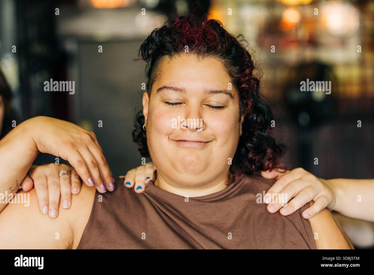 Personne recevant un massage de l'épaule souriant avec les yeux fermés Banque D'Images