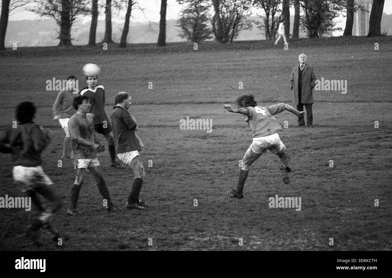 Hommes jouant au football dans un parc dans les années 1970, Royaume-Uni Banque D'Images
