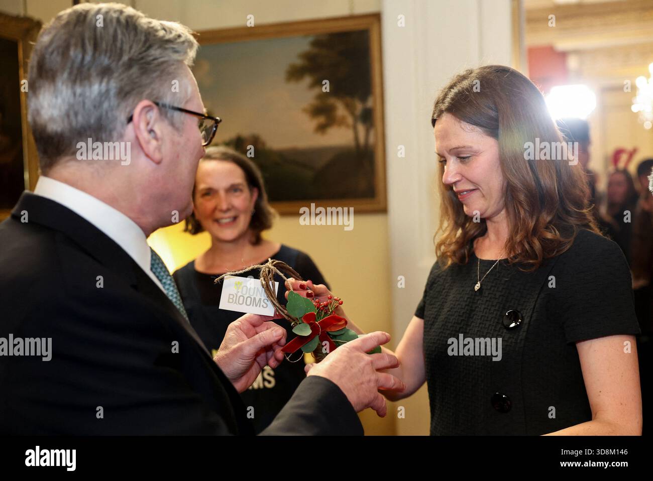 Le premier ministre Sir Keir Starmer et son épouse Lady Victoria Starmer portent une décoration florale alors qu’ils accueillent une vitrine de Noël de style marché pour les petites entreprises et les champions communautaires au 10 Downing Street, à Londres. Date de la photo : lundi 1er décembre 2025. Banque D'Images