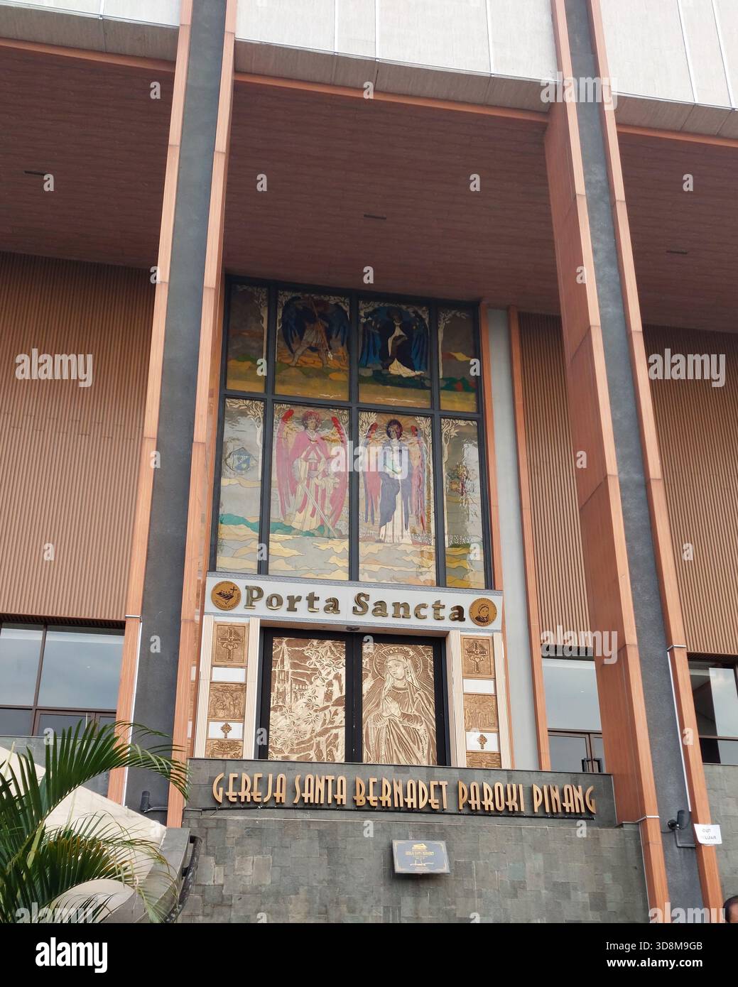 Une façade d'église catholique moderne avec l'entrée de Porta Sancta, des vitraux et des détails architecturaux en bois et en pierre. Idéal pour rel Banque D'Images