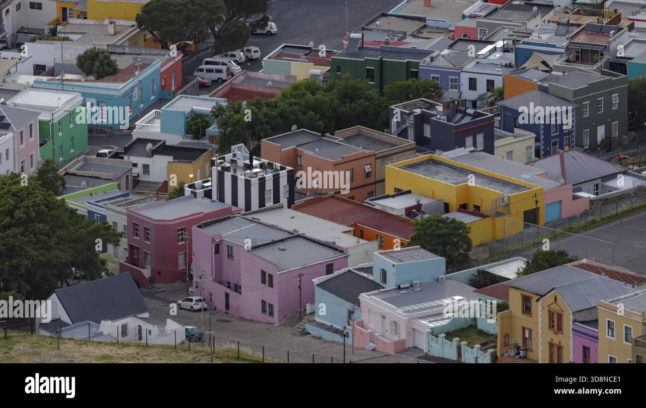 Vue de bâtiments multicolores dynamiques nichés ensemble créant un patchwork de couleurs, avec des voitures garées entre les bâtiments, Cape Town, Western CA Banque D'Images