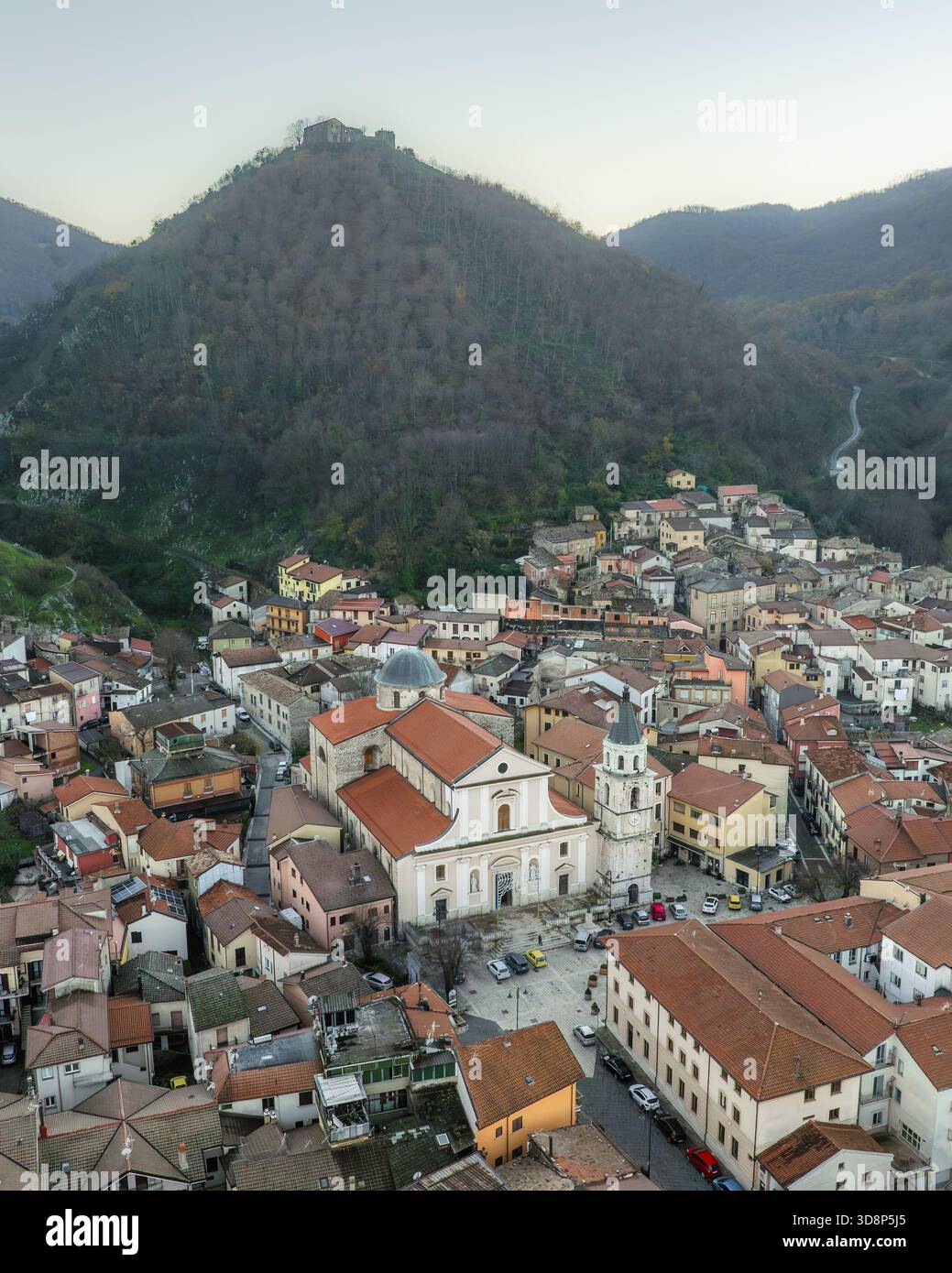Vue aérienne des toits en terre cuite en cascade autour de la Chiesa Madre di San Michele Arcangelo sur fond de montagne spectaculaire, Volturara Irpina, Banque D'Images