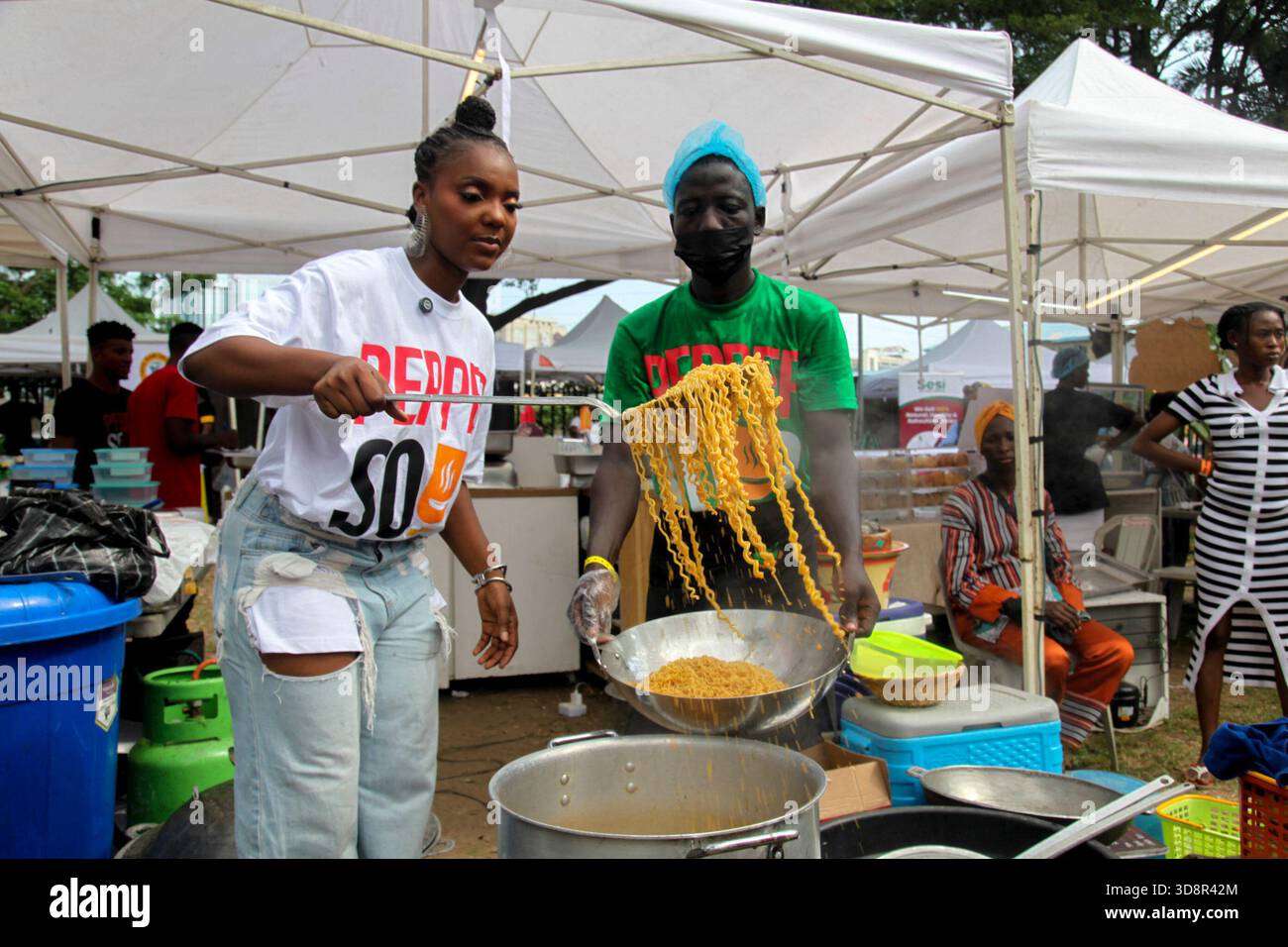 Une femme cuisine des pâtes lors du Firewood Jollof Festival 2,0 au parc Muri Okunola, Victoria Island, Lagos, Nigeria, le 30 novembre, 2025. (photo de Adekunle Ajayi/NurPhoto)0 Banque D'Images
