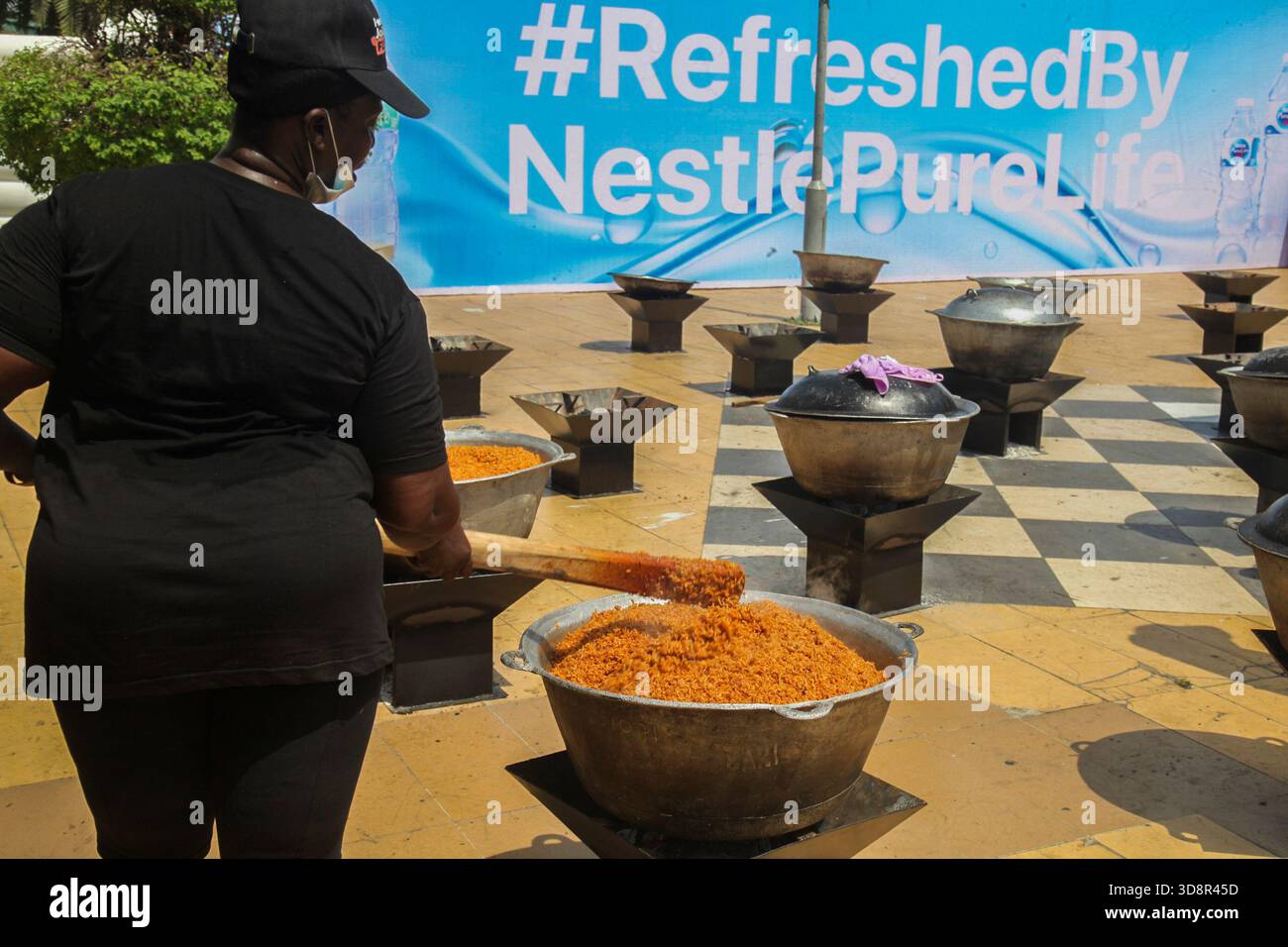 Une femme cuisine du riz lors du Firewood Jollof Festival 2,0 au parc Muri Okunola sur l'île Victoria, Lagos, Nigeria, le 30 novembre 2025. (Photo de Adekunle Ajayi/NurPhoto) Banque D'Images