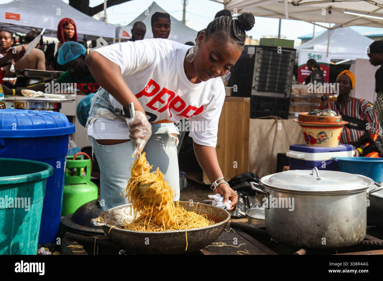Une femme cuisine des pâtes lors du Firewood Jollof Festival 2,0 au parc Muri Okunola, Victoria Island, Lagos, Nigeria, le 30 novembre, 2025. (photo de Adekunle Ajayi/NurPhoto) Banque D'Images