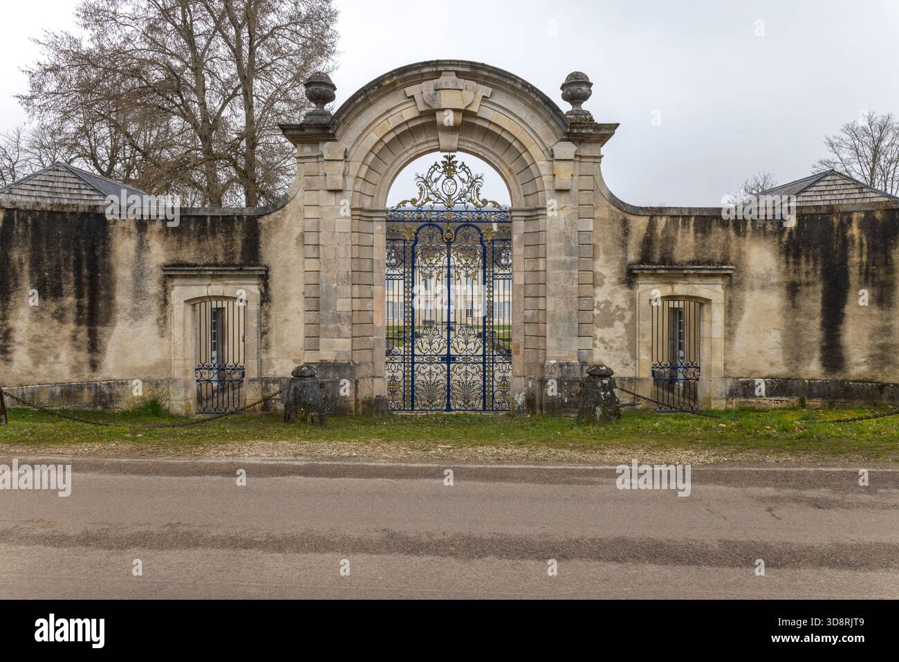 Portail en fer forgé orné d'une architecture historique en pierre à Auberive, France Banque D'Images