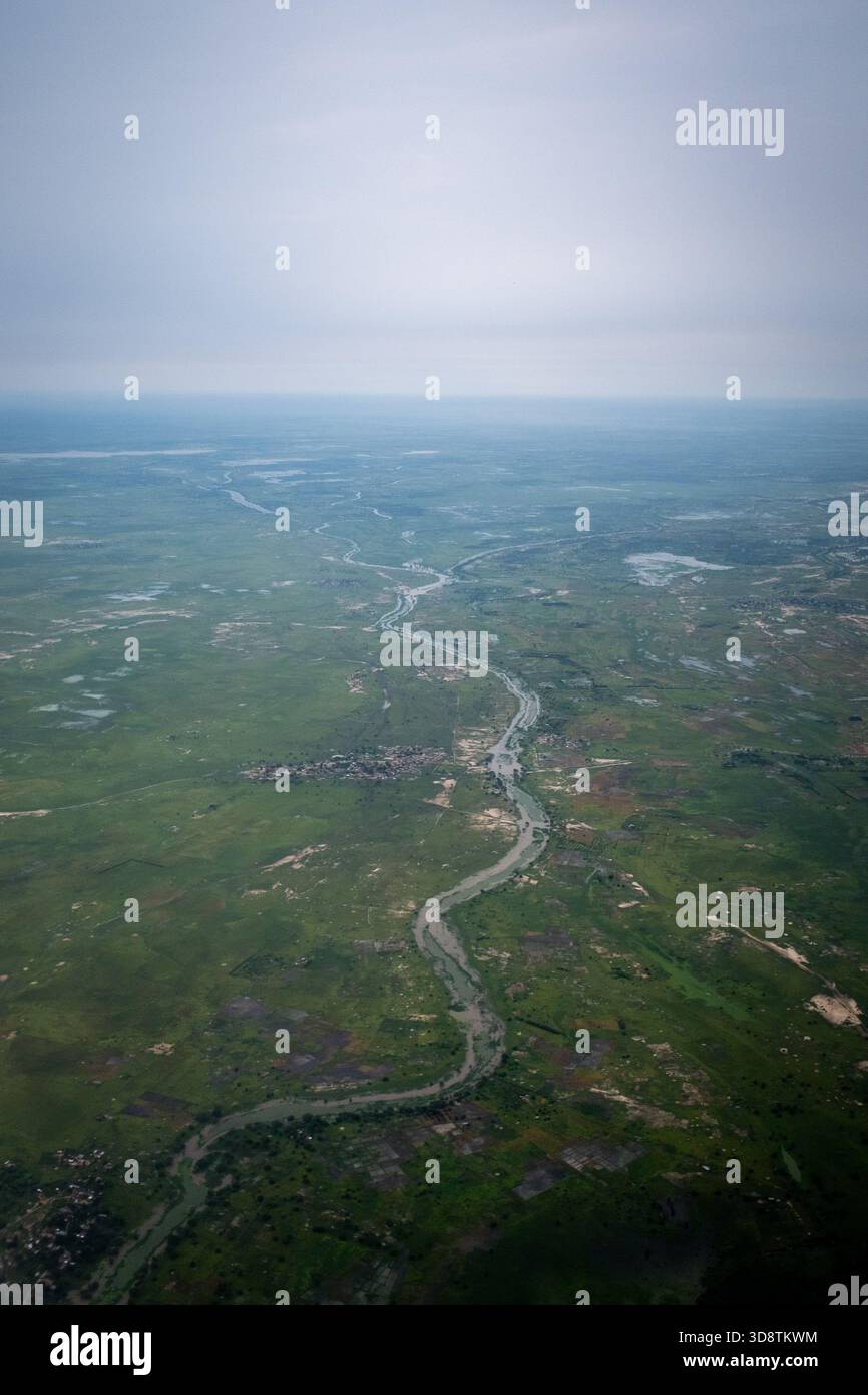 Vue aérienne d'une rivière sinueuse traversant un paysage rural verdoyant près de N Djamena au Tchad le 27 août 2024. L'image montre des villages dispersés, des parcelles Banque D'Images
