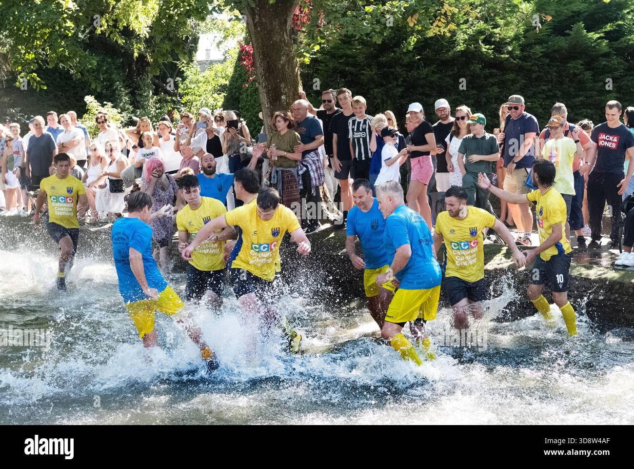 Chaque année Bourton sur l'eau dans les Cotswolds organise un match de football dans la rivière Windrush à travers la charmante ville un centre de tourisme, tous sont très mouillés Banque D'Images