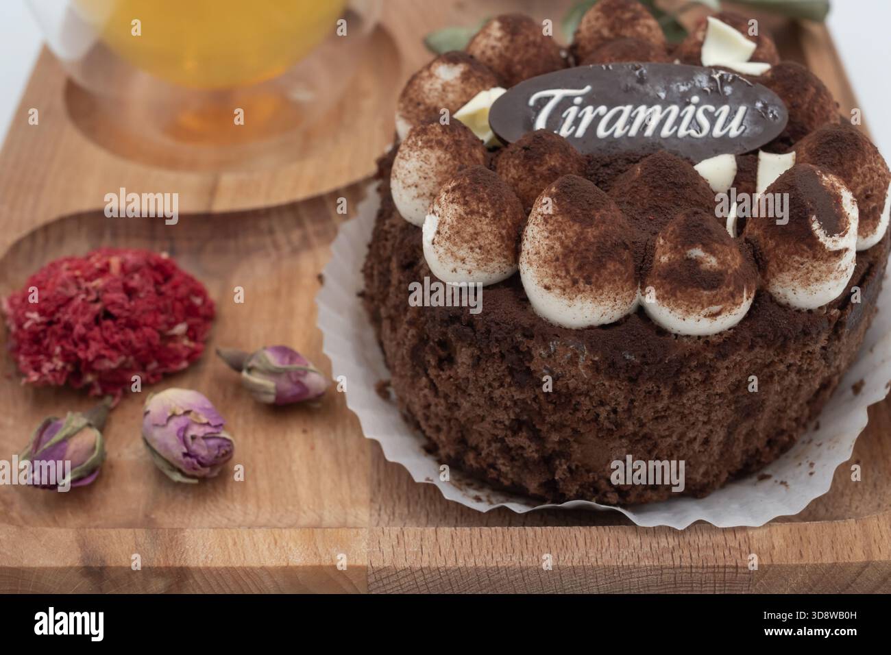 Dessert tiramisu avec tisane sur plateau en bois avec fleurs séchées et feuilles d'eucalyptus sur un fond blanc propre Banque D'Images