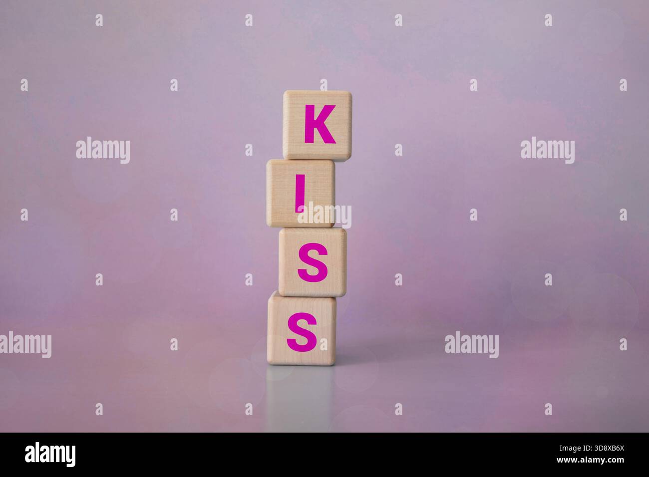 Le mot KISS est formé de blocs de bois sur un tissu bleu. Libérer de l'espace pour écrire. Banque D'Images