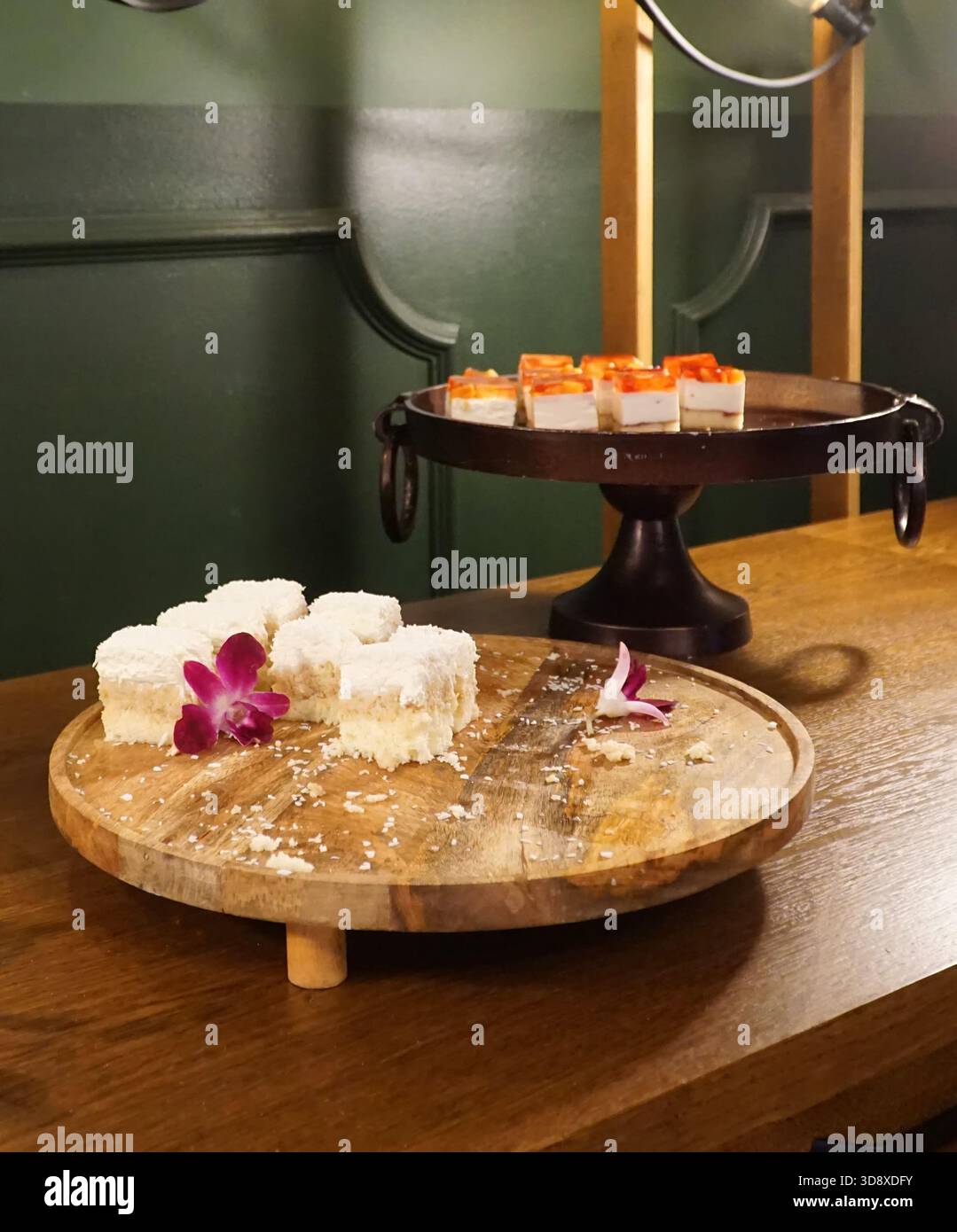 Morceaux de gâteau à la noix de coco et cheesecake avec gelée de fruits sur des assiettes décoratives. Mise au point sélective. Banque D'Images