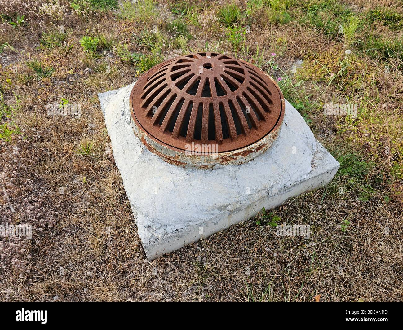 Vue latérale du couvercle de grille de trou d'homme en métal bombé rouillé pour l'évacuation des eaux pluviales Banque D'Images