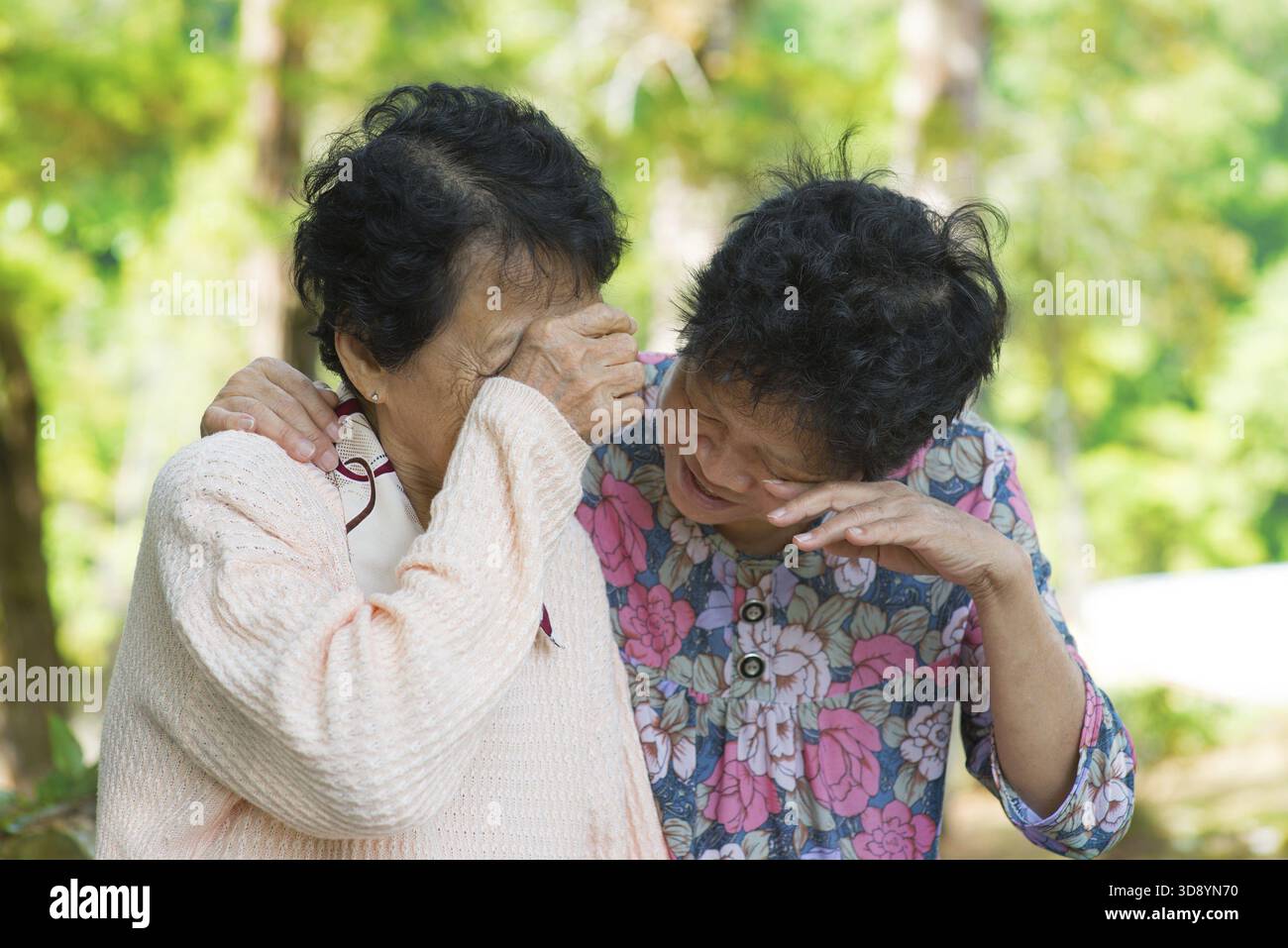 Tristes femmes asiatiques âgées dans le deuil de la perte d'un être cher. Parc extérieur Banque D'Images