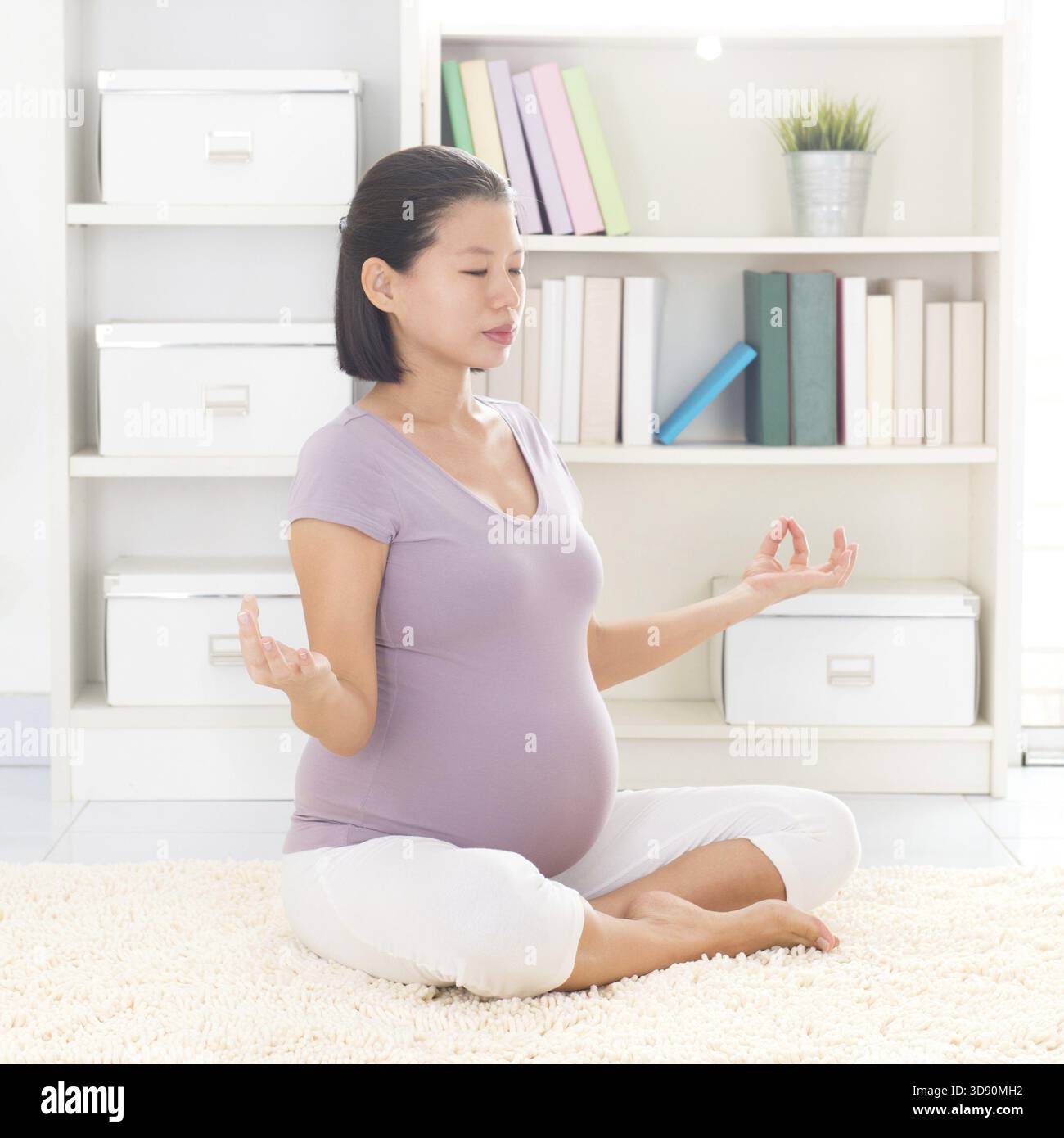 Méditation yoga grossesse. Pleine longueur saine 8 mois enceinte calme femme asiatique méditant ou faisant de l'exercice de yoga à la maison. Posture de yoga relaxation Banque D'Images
