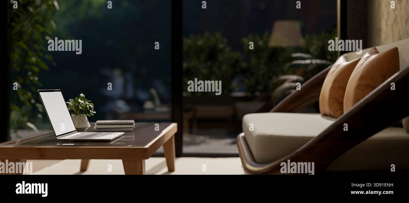 Ordinateur portable à écran blanc sur une table en bois devant un canapé ou un fauteuil dans le salon avec porte vitrée la nuit. Intérieur de la maison, rendu 3D, illustration 3D. Banque D'Images