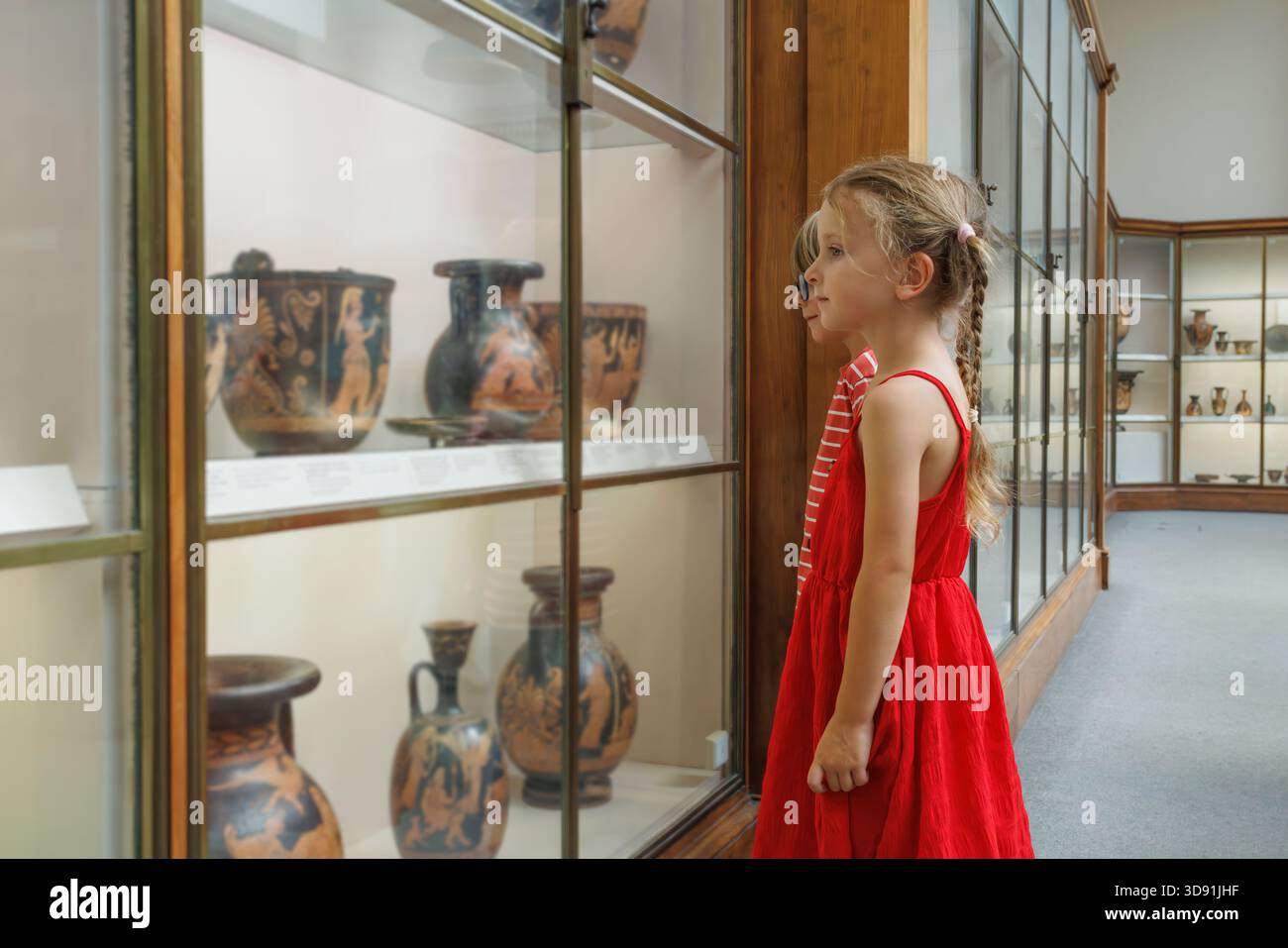 Deux enfants touristes observant une ancienne poterie dans une vitrine en verre Banque D'Images