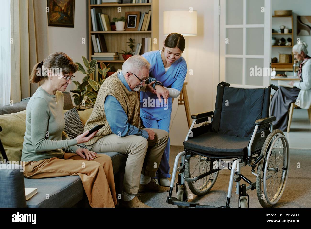 Femme d'âge moyen aidant homme âgé handicapé Banque D'Images