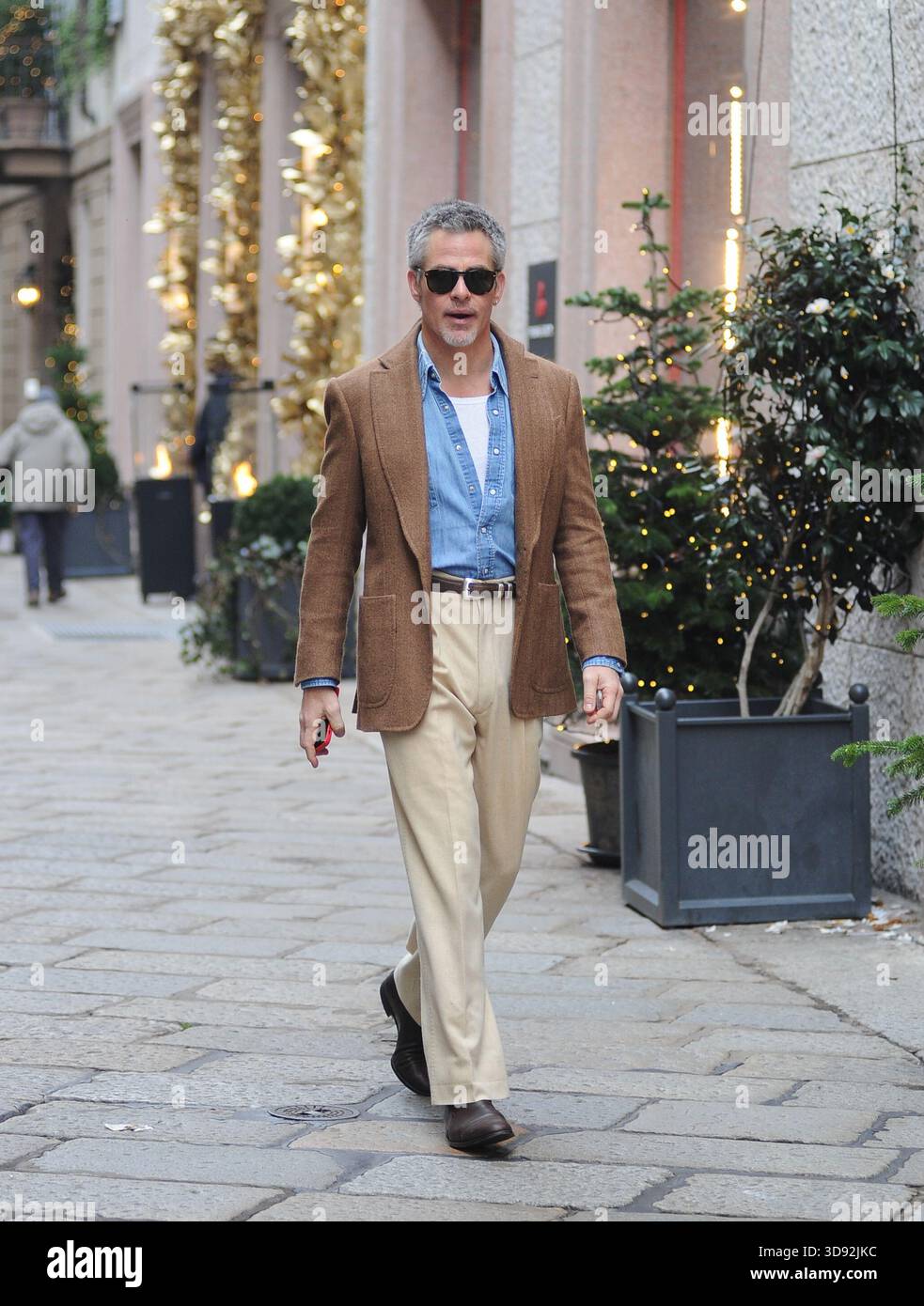 L'acteur américain Chris Pine se promène dans les rues du centre-ville de Milan, puis, avec un ami, entre dans la boutique Ralph Lauren pour faire du shopping et prend un taxi pour retourner à l'hôtel. Banque D'Images