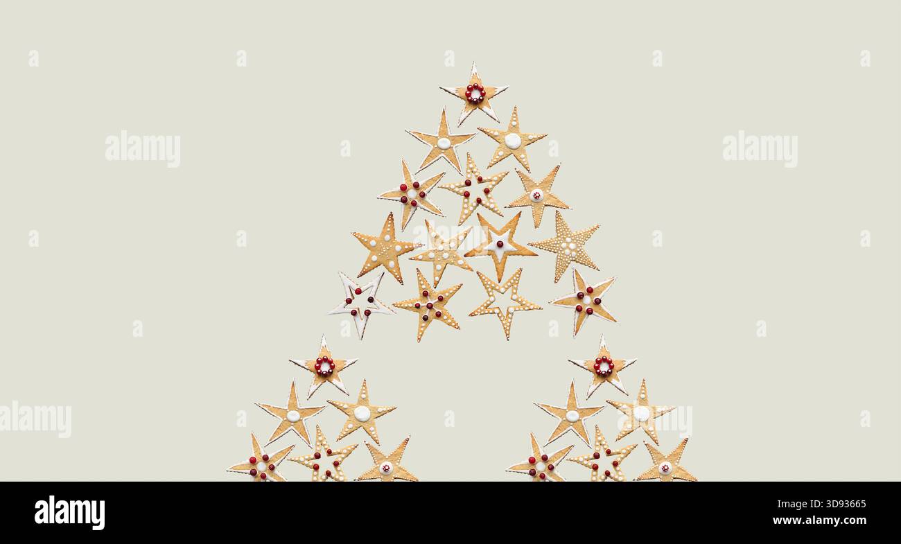 Arbre de Noël fait de biscuits au sucre en forme d'étoile de gingembre. Ornement conceptuel de nourriture sucrée de Noël. Nourriture décorée à la main. Isolé. Bannières d'hiver Banque D'Images