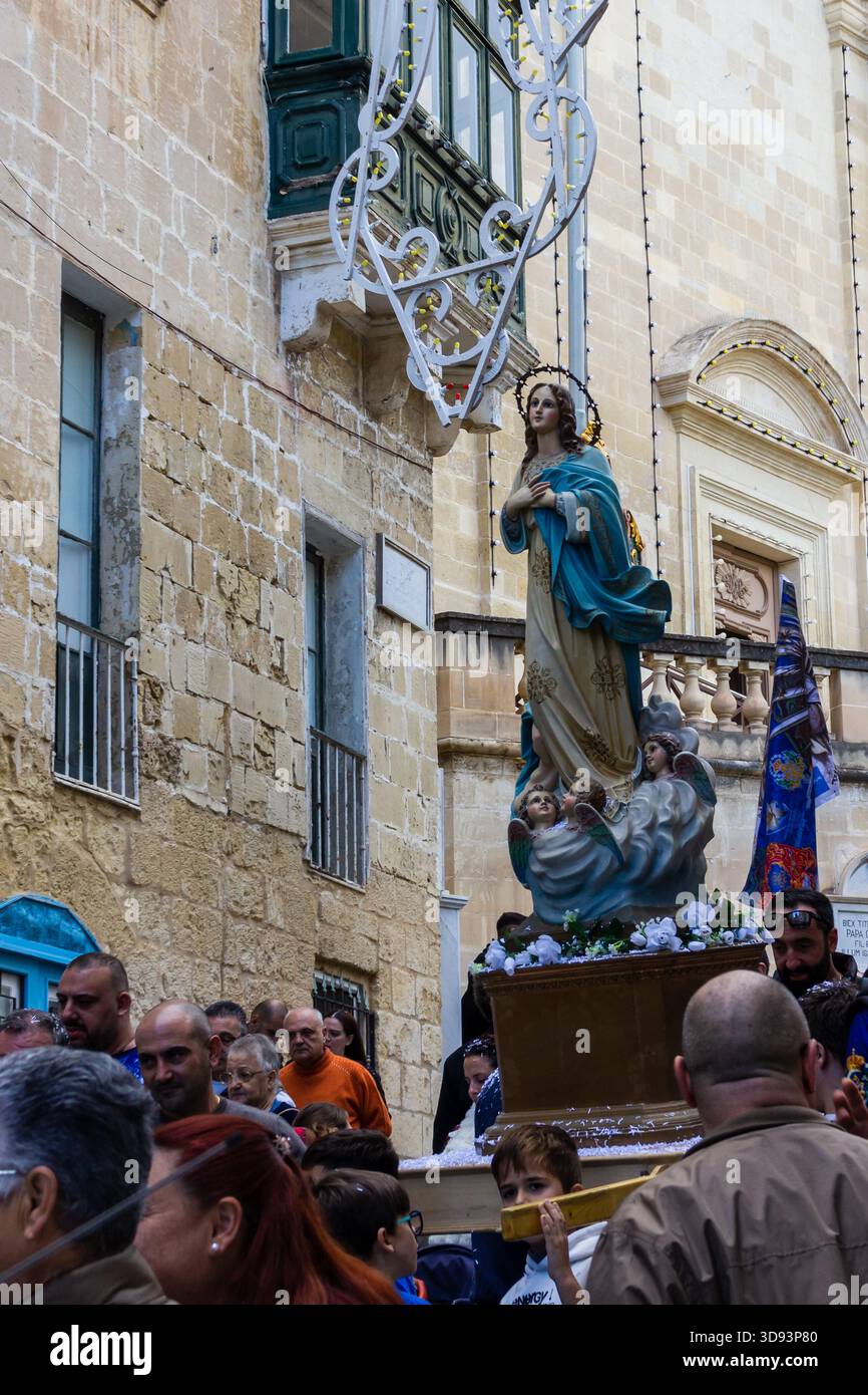 Cospicua, Malte - le 30 novembre 2025, procession du festival religieux avec la statue de la Vierge Marie au milieu de défilé de rue bondée pendant la célébration festive Banque D'Images