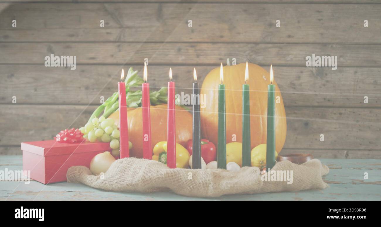 Affichage kinara sept bougies allumées brillantes sur le dessus de table bleu pâle porté avec un cadeau rouge de raisins de citrouille Banque D'Images