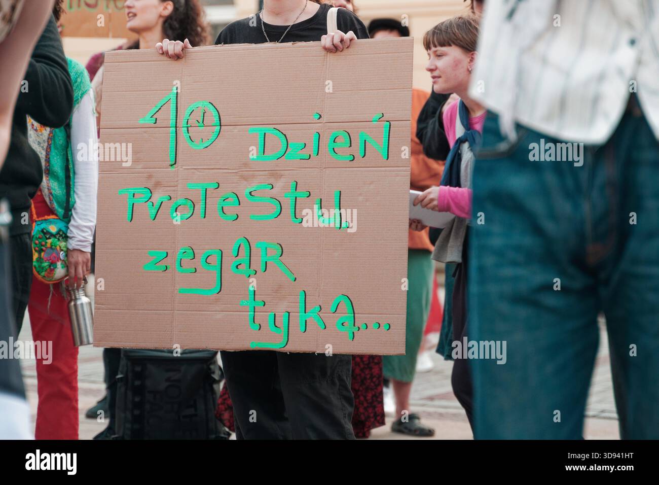 Manifestant tenant une pancarte en carton en polonais indiquant « 10ème jour de protestation, l’horloge tourne » lors d’un rassemblement pro-palestinien. Banque D'Images