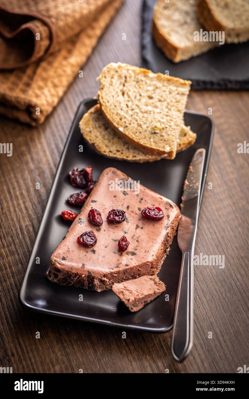 Pâté de foie avec des canneberges sur une plaque noire. Banque D'Images